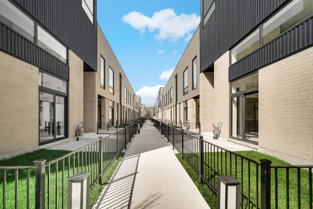 Exterior Walkway down the center of the townhome community, with the front entrances of units on either side facing the walkway.